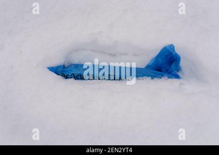 Eine nach Hause gelieferte Kopie der New York Times in einer schneebedeckten Auffahrt in Santa Fe, New Mexico. Stockfoto