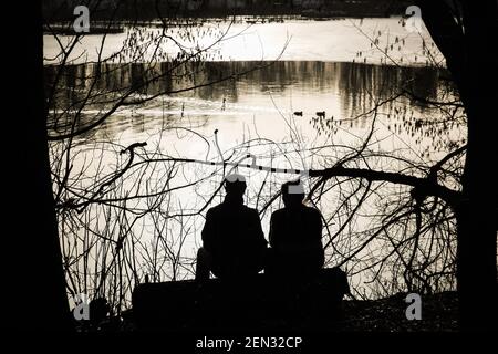 Berlin, Deutschland. Februar 2021, 25th. Zwei Besucher genießen den Sonnenschein am Tegeler See in Berlin, der Hauptstadt Deutschlands, 25. Februar 2021. Quelle: Shan Yuqi/Xinhua/Alamy Live News Stockfoto