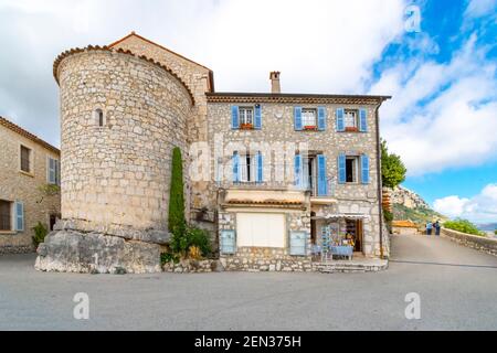 Touristen genießen den Panoramablick auf das Tal von einer Terrasse in der Nähe Ein Schlossladen im mittelalterlichen Dorf Gourdon in Alpes Maritime von Südfrankreich Stockfoto