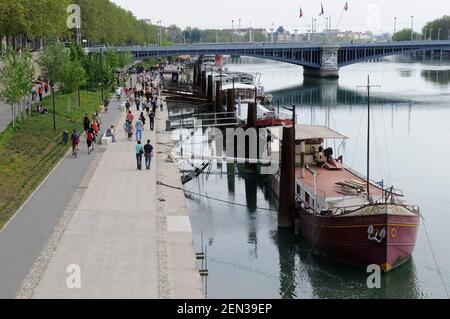 An den Ufern der Rhone wurden Lastkähne gefesselt Mit Leuten, die auf dem Fußweg laufen Stockfoto