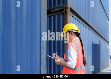 Asiatische Arbeiterin prüft den Behälter nach der Reparatur abgeschlossen, um die Lieferung an den Kunden vorzubereiten. Stockfoto