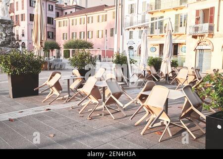 Straßencafé mit leeren Tischen in der kleinen italienischen Stadt für Quarantäne geschlossen. Lecco, Italien - 08. November 2020. Stockfoto