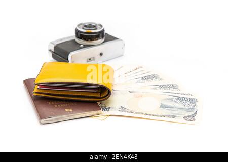 Die gelbe Geldbörse wurde auf den Pass gelegt und die Banknoten und die Kamera waren auf weißem Hintergrund. Isoliert. Stockfoto