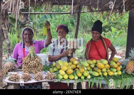 Papua-Neuguinea Frauen verkaufen frische Erdnüsse und Gurken auf einem Straßenmarkt in den westlichen Highlands, Papua-Neuguinea. Stockfoto