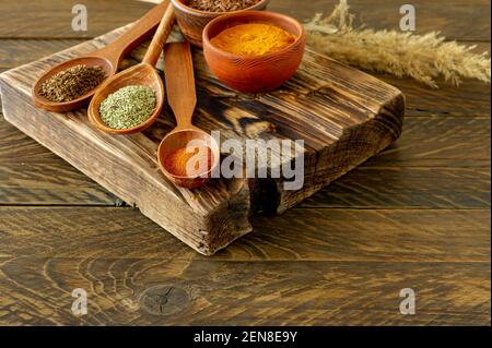 Pudergewürze auf Löffeln auf Holzhintergrund. Stockfoto