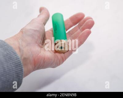 Die grüne Schale der Patrone des Jagdgewehrs liegt auf der Handfläche Ältere Frau Stockfoto