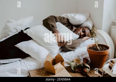 Nachdenklicher Mann liegend im Bett zu Hause Stockfoto