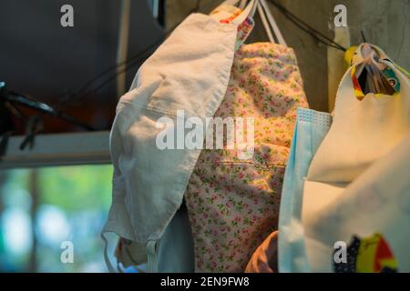 An der Wand hängende Gesichtsmasken umfassen medizinische Maske und Stoffmaske und Baumaske. Konzept der Wirksamkeit von Standard-Gesichtsmasken im Vergleich zu re Stockfoto