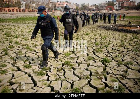 Kathmandu, Nepal. Februar 2021, 26th. Polizeibeamte gehen am Freitag, den 26. Februar 2021, in Kathmandu zu Fuß, um Aktivisten davon abzuhalten, Betonmaterial zu beschädigen. Sie fordern eine ordnungsgemäße Restaurierung des jahrhundertealten Kamal Pokhari in Kathmandu. Kamal Pokhari ist ein historischer Teich im Herzen der Hauptstadt. Kredit: Skanda Gautam/ZUMA Wire/Alamy Live Nachrichten Stockfoto