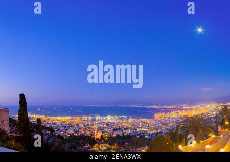 Abendansicht des Bahai-Schreins und der Gärten, mit der Innenstadt, dem Hafen und dem Mond, in Haifa, Nord-Israel Stockfoto