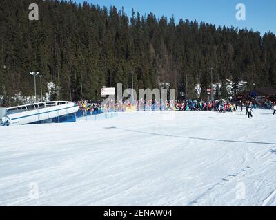 Białka Tatrzańska, Polen - 23. Februar 2021: Eine lange Schlange von Skifahrern und Snowboardern zum Skilift bei sonnigem Wetter Stockfoto