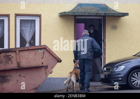 Thüringen, Ballstädt, 26. Februar 2021: Ein Polizeibeamter mit einem drogenschnüffenden Hund betritt ein Haus, das mit der rechten Szene in Verbindung steht. Die Polizei in mehreren Bundesländern hat mit einer groß angelegten Razzia gegen ein Neonazi-Netzwerk eingegriffen. Bei den Durchsuchungen in Thüringen, Sachsen-Anhalt und Hessen ging es um den Verdacht des groß angelegten Drogenhandels und der Geldwäsche, teilte das Landeskriminalamt Thüringen (TLKA) am Freitagmorgen mit. Foto: Michael Reichel/dpa-Zentralbild/dpa Quelle: dpa picture Alliance/Alamy Live News Stockfoto