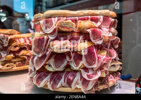 Mehrere Jamon serrano Sandwiches stapelten sich in einem Schaufenster, konzeptuelles Bild Stockfoto