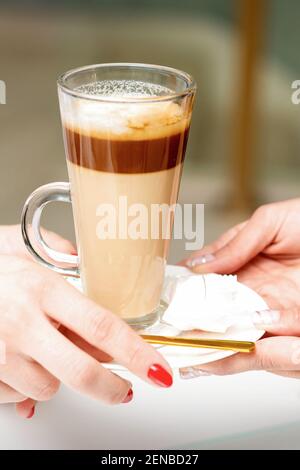 Nahaufnahme der Hände der Frau, die den Latte-Becher aus den Händen nimmt Eines Barista in einem Café Stockfoto