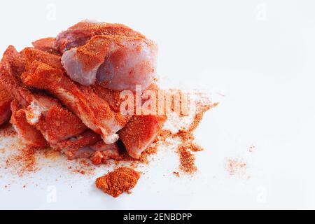 Schweinefilet in Stücke geschnitten und mit trockenen Gewürzen überzogen, fertig zum Grillen, auf weißem Hintergrund, Kopierplatz Stockfoto
