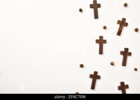 Hintergrund mit Holzkreuzen und runden Perlen rechts auf Holztisch angeordnet. Horizontale Zusammensetzung. Stockfoto