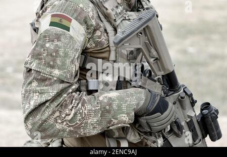 Soldat mit Sturmgewehr und Flagge Boliviens auf Militäruniform. Collage. Stockfoto