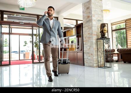 Ein vielbeschäftigter Mann, der in einem Anzug in der Lobby war Stockfoto