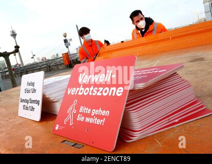 26. Februar 2021, Nordrhein-Westfalen, Düsseldorf: Mitarbeiter des Düsseldorfer Verkehrsunternehmens bereiten sich auf das Aufhängen der Verbotszone - Bitte gehen Sie weiter. Die Regeln gelten freitags von 3 bis 1 Uhr und samstags/sonntags von 10 bis 1 Uhr.Foto: Roland Weihrauch/dpa Stockfoto