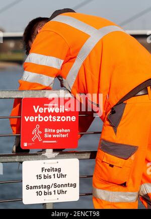 26. Februar 2021, Nordrhein-Westfalen, Düsseldorf: Ein Mitarbeiter der Düsseldorfer Verkehrsbetriebe legt ein Verbotsschild 'Verweilverbotszone - Bitte gehen Sie weiter' auf. Die Regeln gelten freitags von 3 bis 1 Uhr und samstags/sonntags von 10 bis 1 Uhr.Foto: Roland Weihrauch/dpa Stockfoto