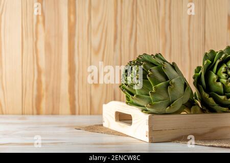 Reife Bio Artischocken auf einem weißen Holztisch. Gemüsehintergrund. Stockfoto