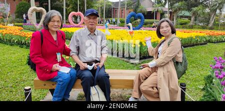 Taipei, Taiwan, Februar 26 2021: Dekorative holländische Mühle und ein Boot mit zwei Figuren am Eingang zum Shilin Residence Park für die Tulip Show 2021 Stockfoto