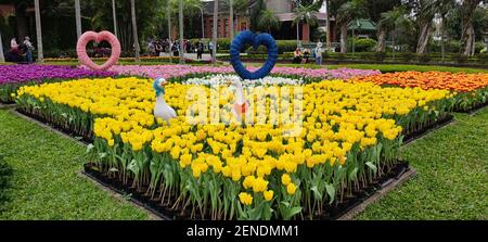 Taipei, Taiwan, Februar 26 2021: Dekorative holländische Mühle und ein Boot mit zwei Figuren am Eingang zum Shilin Residence Park für die Tulip Show 2021 Stockfoto