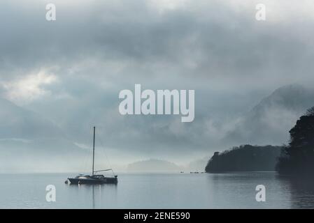 Episches Landschaftsbild mit Blick über Derwentwater im Lake District Catbells schneebedeckter Berg mit dichtem Nebel Rollen durch Tal Stockfoto