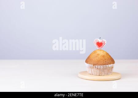 Hausgemachte Muffins mit herzförmigen Kerzen auf weißem Hintergrund. Feiertag und Valentinstag Geschenkkarte Hintergrund mit Kopierplatz. Stockfoto