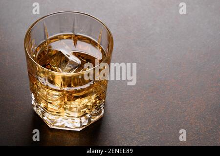Glas kalten Whiskys auf dunkelbraunem Hintergrund. Nahaufnahme. Stockfoto