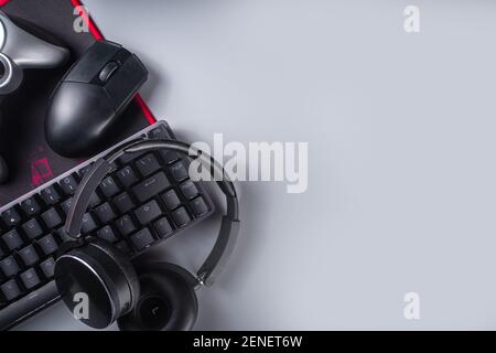 Konzept für Gaming- und Gamer-Geräte. Gamer Arbeitstisch Raum Hintergrund, Draufsicht. Tastatur, Maus, Gamepad Joystick, Mauspad und Kopfhörer. Auf grau ta Stockfoto