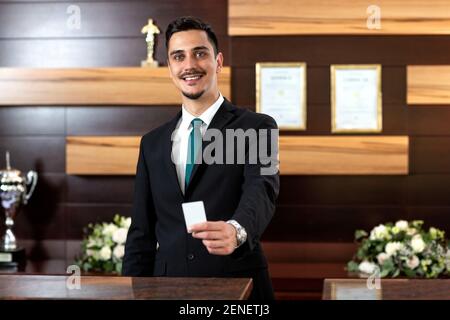 Der Rezeptionist hält eine Schlüsselkarte in der Hand Stockfoto