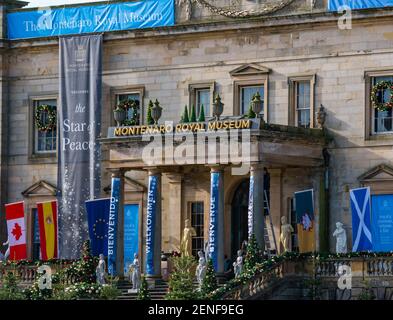 East Lothian, Schottland, Vereinigtes Königreich, 26th. Februar 2021. Princess Switch Drehort: Das Gosford House verwandelt sich in das Montenaro Royal Museum für einen Weihnachtsfilm des dritten Teils der romantischen Netflix-Komödie mit Vanessa Hudgens, Kränzen an den Fenstern, Weihnachtsbäumen und Dekorationen sowie Vorbereitungen für gefälschten Schnee. Die Banner und internationalen Flaggen deuten auf ein internationales Friedensereignis in der Handlung hin Stockfoto