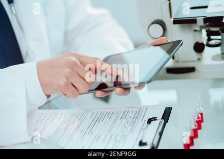 Wissenschaftler arbeiten an einem Tablet und gehen über Forschungsnotizen. Stockfoto