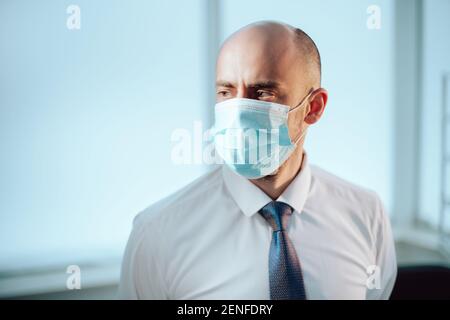 Wissenschaftler in einer Schutzmaske auf dem Hintergrund eines medizinischen Labors. Stockfoto