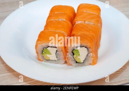 Brötchen mit Fisch Avocado und Gurke in einem Teller mit sojasauce und Wasabi Stockfoto