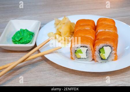 Brötchen mit Fisch Avocado und Gurke in einem Teller mit sojasauce und Wasabi Stockfoto