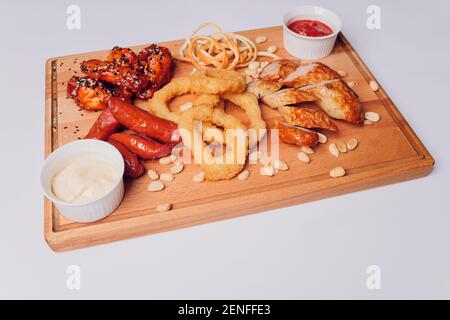 Große Auswahl an Snacks für Bier mit verschiedenen Soßen auf Pergament, Ansicht von oben Stockfoto