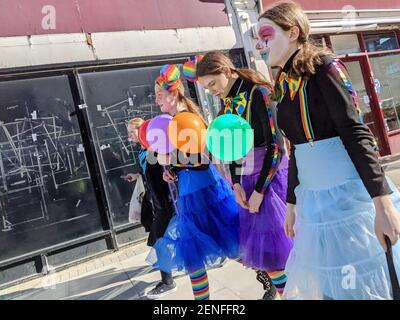 Jüdische Kinder feiern den jüdischen Feiertag Purim (Fest der Lose) in Golders Green - einer großen jüdischen Gemeinde im Nordwesten Londons. 4 Mädchen als Clowns mit Gesichtsfarbe und Luftballons gekleidet. Stockfoto