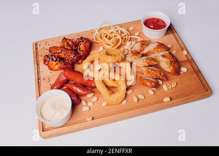 Große Auswahl an Snacks für Bier mit verschiedenen Soßen auf Pergament, Ansicht von oben Stockfoto