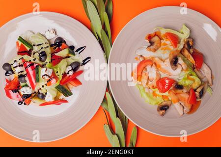 Set von Salaten auf dunklem Hintergrund. Griechischer Salat, Caesar Salat, Gemüsesalat Stockfoto