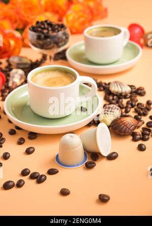 Kapseln für eine Espressomaschine in der Hand. Aromatischer italienischer Kaffee . Arabica-Kaffeebohnen für die Zubereitung eines traditionellen Getränks. Vertikal . Hochwertige Fotos Stockfoto