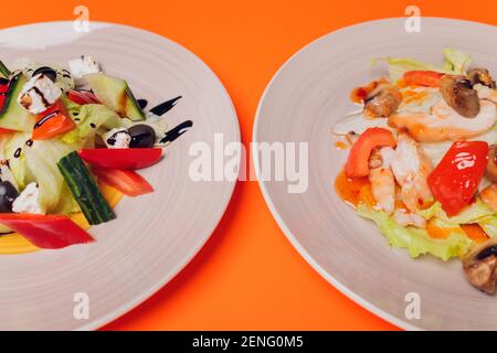 Set von Salaten auf dunklem Hintergrund. Griechischer Salat, Caesar Salat, Gemüsesalat Stockfoto