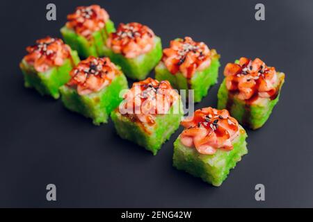 Traditionelle japanische Küche, Mix bunte sushiSet von verschiedenen Arten von Sushi-Rollen mit Lachs, Garnelen und Gemüse. Auf schwarzem rustikalem Hintergrund. Oben Stockfoto
