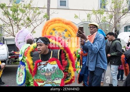 Black Masking Indians (Mardi Gras Indians), verziert in lebendigen gefiederten Anzügen, singen und singen während des Downtown Super Sunday in New Orleans. Stockfoto