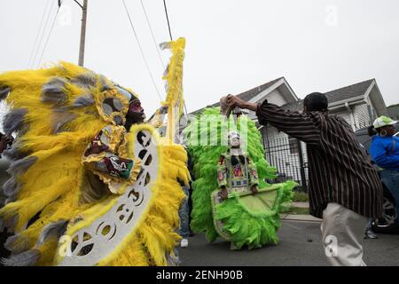 Black Masking Indians (Mardi Gras Indians), verziert in lebendigen gefiederten Anzügen, singen und singen während des Downtown Super Sunday in New Orleans. Stockfoto