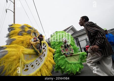 Black Masking Indians (Mardi Gras Indians), verziert in lebendigen gefiederten Anzügen, singen und singen während des Downtown Super Sunday in New Orleans. Stockfoto