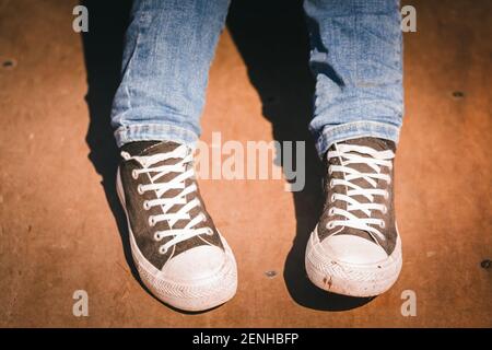 Eine Nahaufnahme einer Person in einem Paar Jeans und ein Paar Schnürschuhe Stockfoto