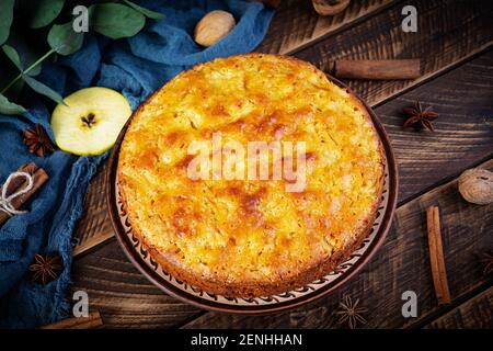 Köstliche hausgemachte Apfelkuchen auf Holz Hintergrund. Apfelkuchen mit Zutaten, Äpfel und Zimt Stockfoto