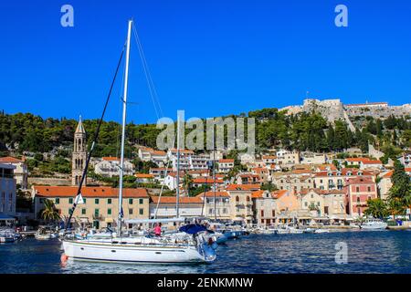 Hvar, Kroatien - 2. Oktober 2011: Blick auf Boote und traditionelle alte Häuser mit der Markuskirche und der spanischen Festung im Hintergrund Stockfoto